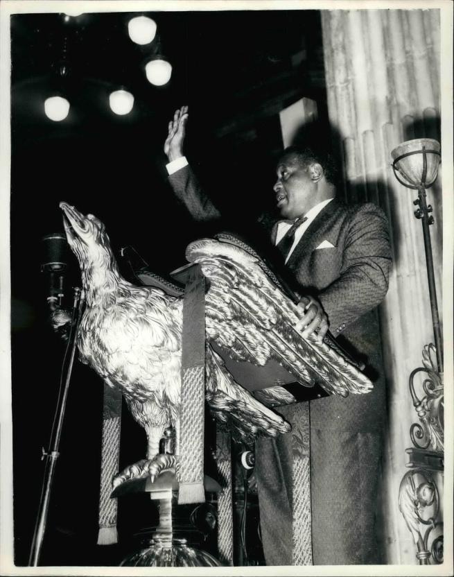 Paul Robeson standing at the eagle lectern, 10 October 1958