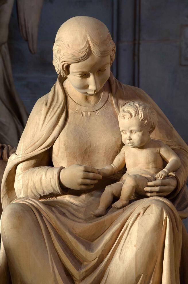 A wooden carved nativity scene with Mary and Baby Jesus