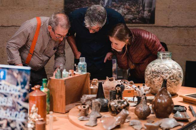 People looking at mudlarking finds.