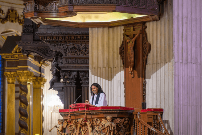 a photo of the pulpit of St Paul's cathedral with a female speaker speaking to a congregation