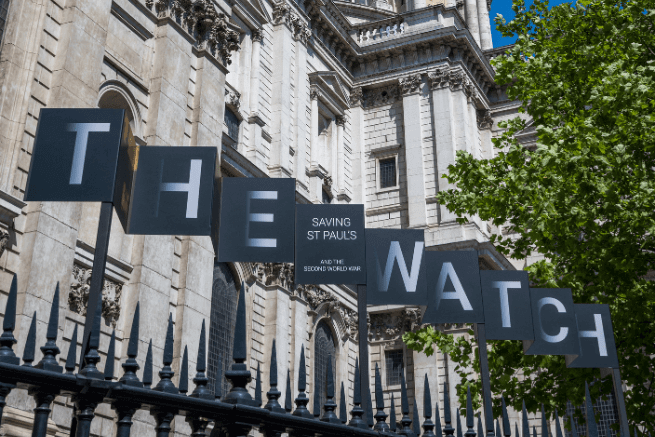 The sign for the exhibition; large letters which spell THE WATCH with 'Saving St Paul's' and 'And the Second World War' in smaller lettering between the two words.