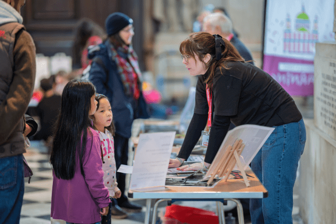 Emma, a member of the Learning team, speaks to two children at Messy Cathedral.