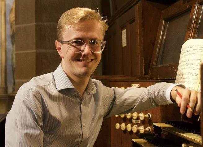 Hamish Wagstaff sits at an organ manual.