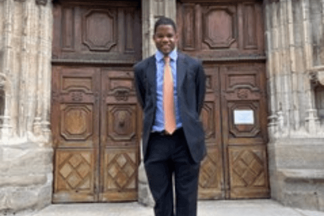 Man standing against a wooden door facing the camera