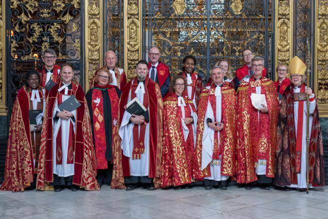 Members of the clergy gather for a photo in front of the Quire gate.