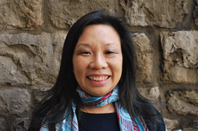 Women wearing a blue patterned scarf and facing the camera