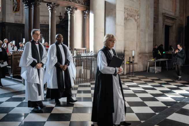 Archbishop Sarah processes followed by two bishops.