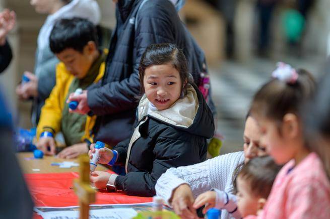 Children using glue in a craft activity at a table