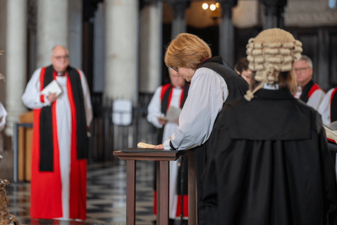 Archbishop Sarah signs a book at the altar.