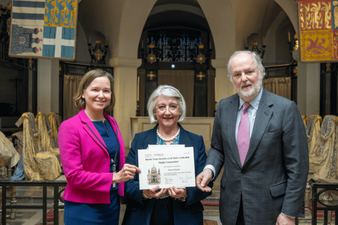 Janet, a volunteer, holds her certificate.