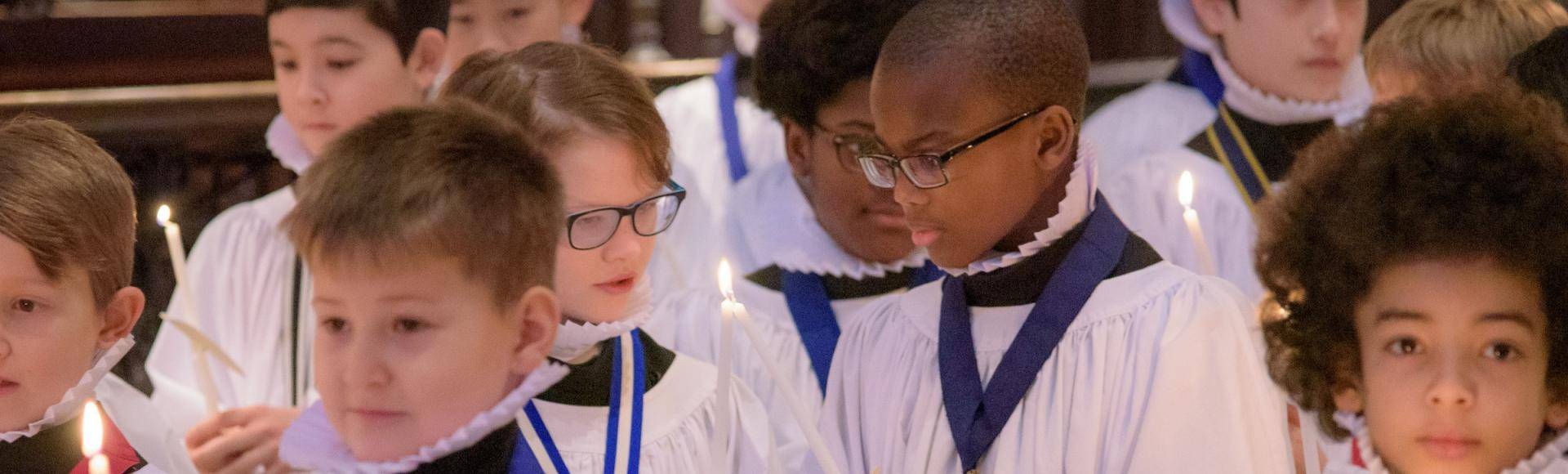 choristers boys sharing candle light christmas