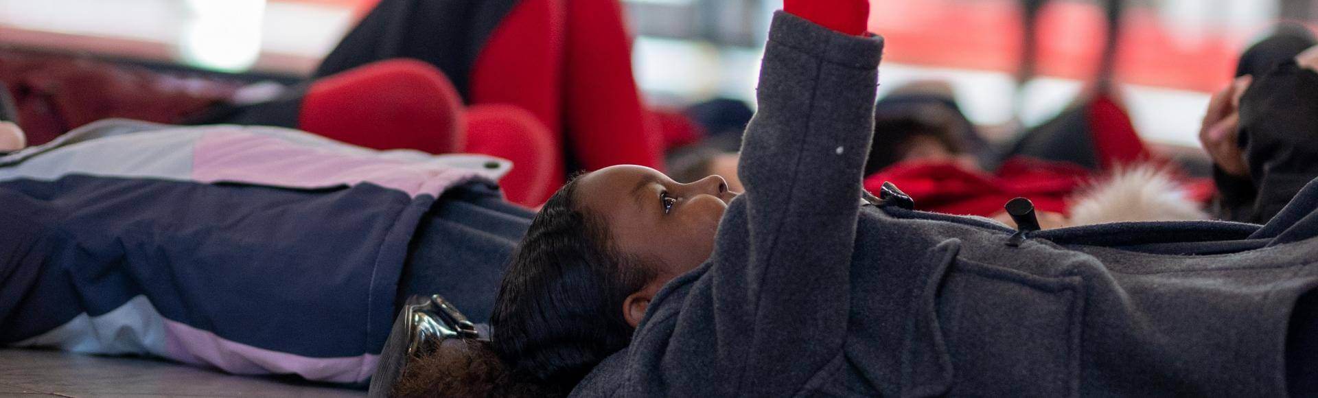 schools child lying down pointing