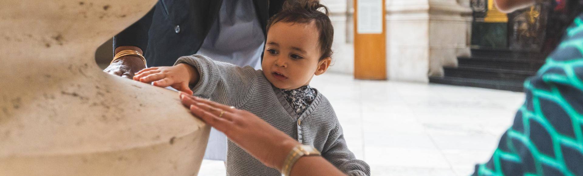 little boy touching cathedral stone