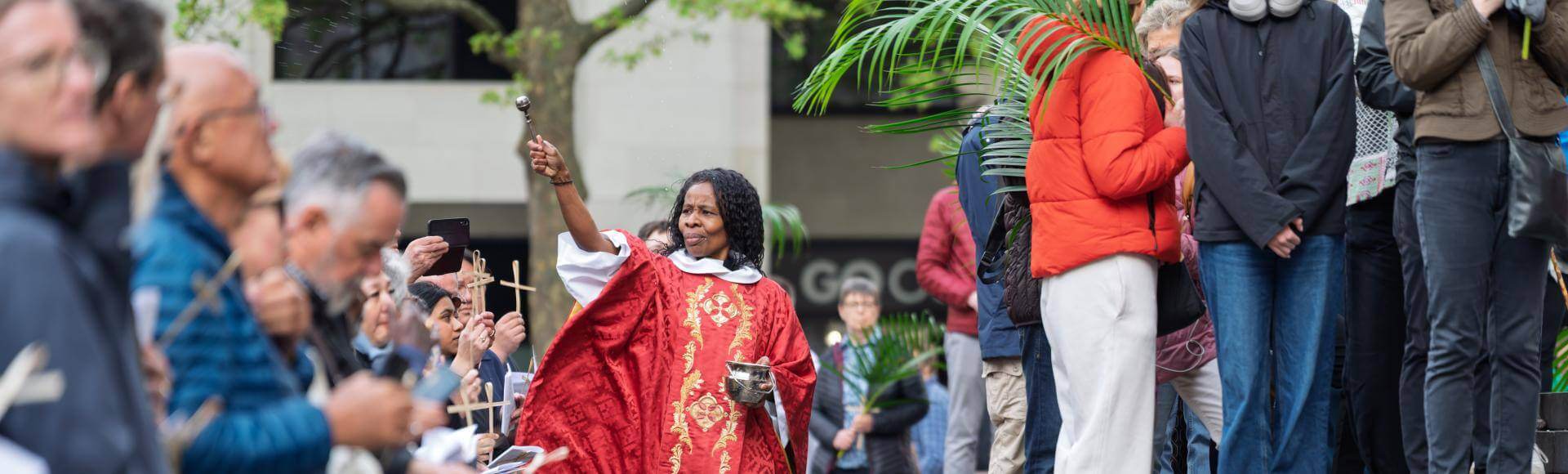 Canon Steward Catherine Okoronkwo blesses the crowd on the West Steps on Palm Sunday.