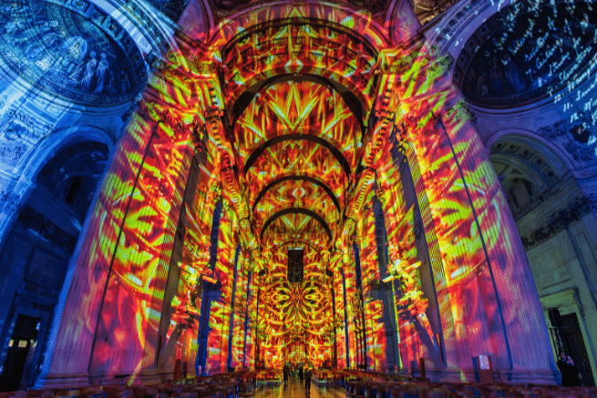 The nave of St Paul's, with a projection of red and orange flames depicting the Great Fire. On each side the walls are blue.