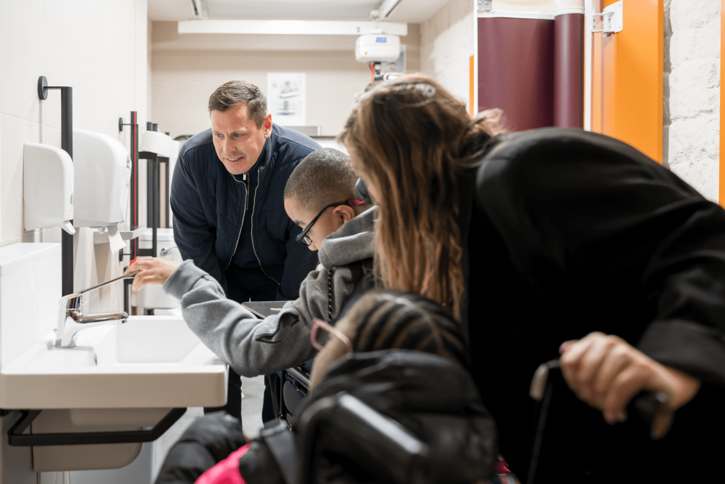 An adult woman and a child using the sink in the new Changing Places toilet