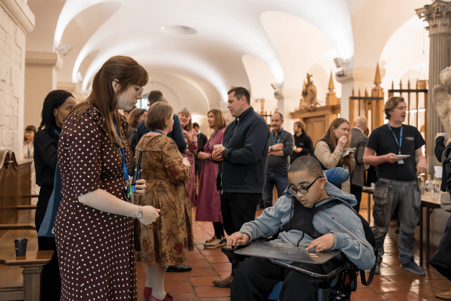 An adult woman talking to a child in a wheelchair