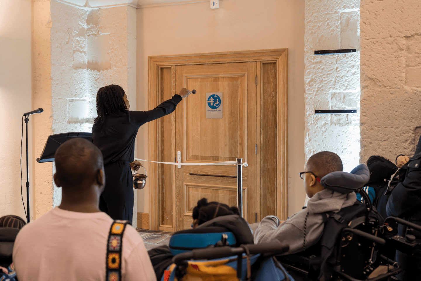 The Canon Steward blessing the toilet door with a sprinkle of water