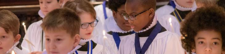 choristers boys sharing candle light christmas