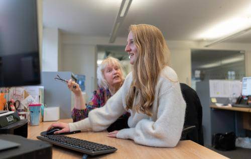 members of staff chatting at desk