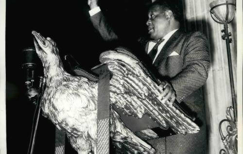 Paul Robeson standing at the eagle lectern, 10 October 1958