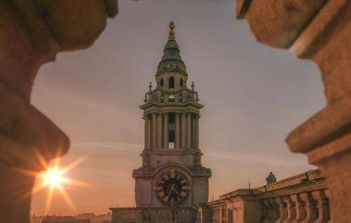 Focus on bell tower with sun in background 
