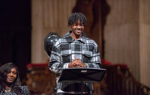 young black man speaking at pulpit as part of special service