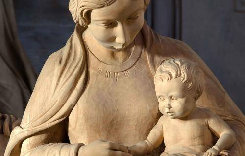 A wooden carved nativity scene with Mary and Baby Jesus