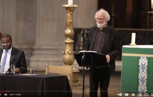 Rowan Williams stands at a lectern on stage at St Paul's Cathedral