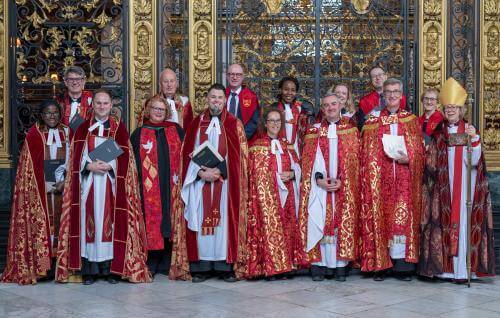 Members of the clergy gather for a photo in front of the Quire gate.