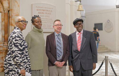 A group of people stand in front of a memorial plaque in the Crypt.