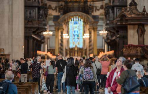 People wander through the Nave with evening light at the east window