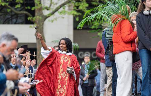 Canon Steward Catherine Okoronkwo blesses the crowd on the West Steps on Palm Sunday.