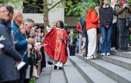 Canon Steward Catherine Okoronkwo blesses the crowd on the West Steps on Palm Sunday.