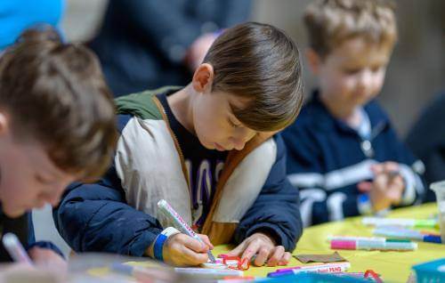 Three children colouring in 