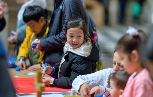Children using glue in a craft activity at a table