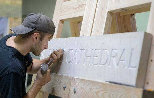 Stonemason James Digger carves the new wordmark.