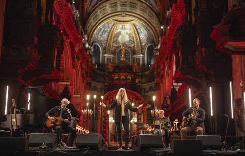 Patti Smith performs a concert under the Dome, surrounded by candles and red lighting.