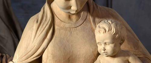 A wooden carved nativity scene with Mary and Baby Jesus