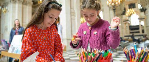 Two young children making badges inside St Paul's Cathedral