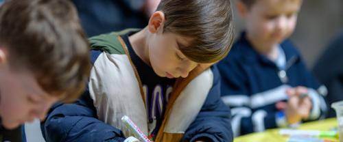Three children colouring in 
